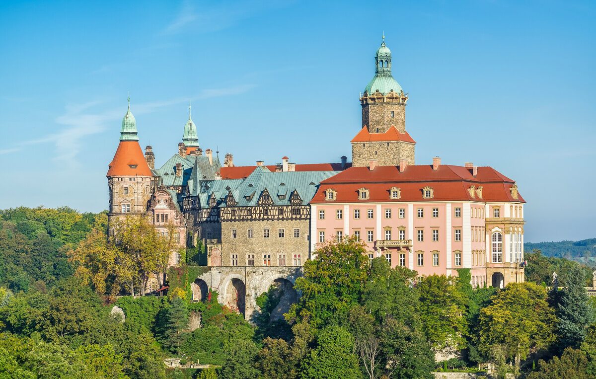 Książ Castle rising over autumn-tinged trees, Poland